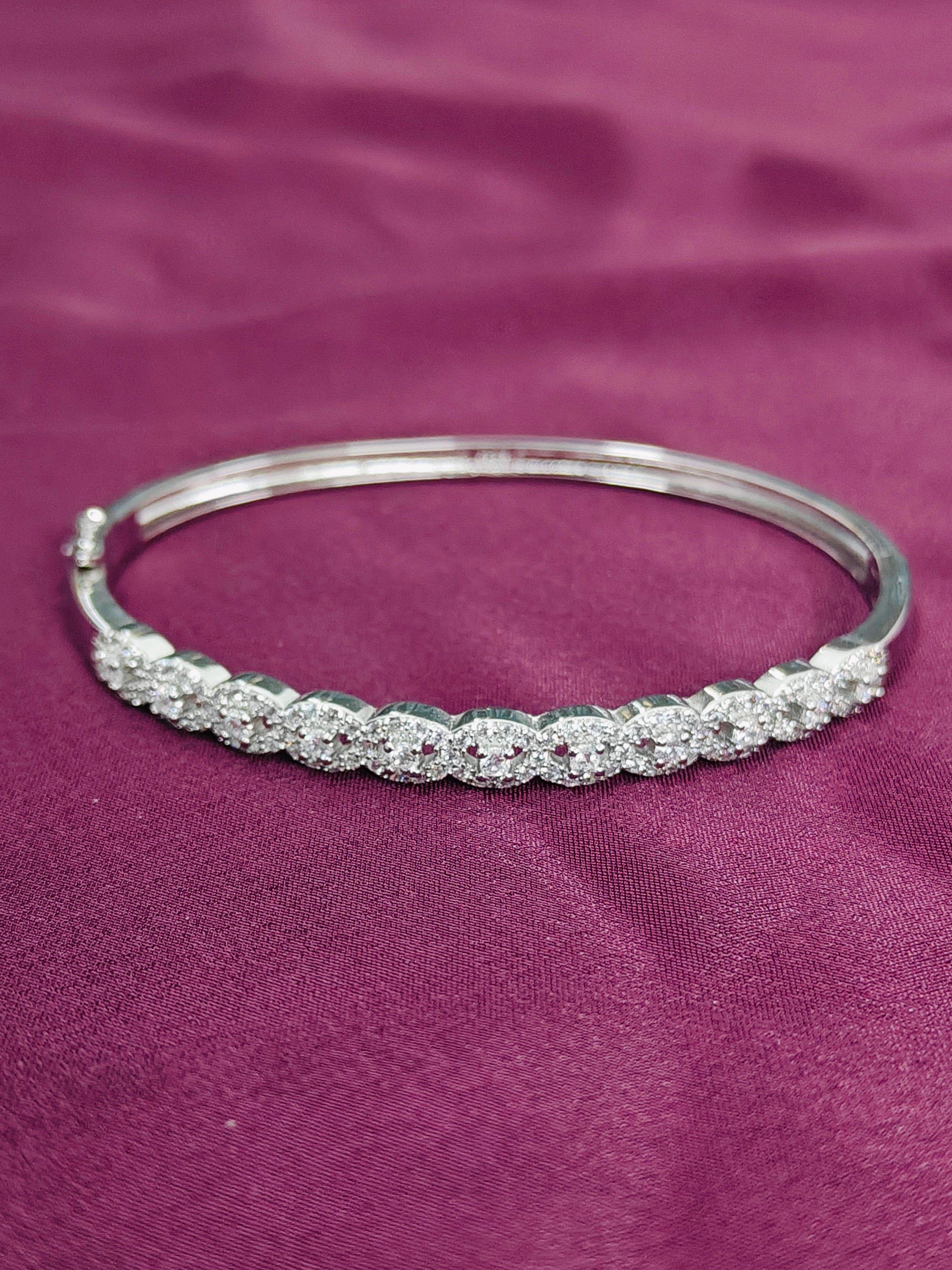 Silver bracelet with clear stones on a purple fabric background